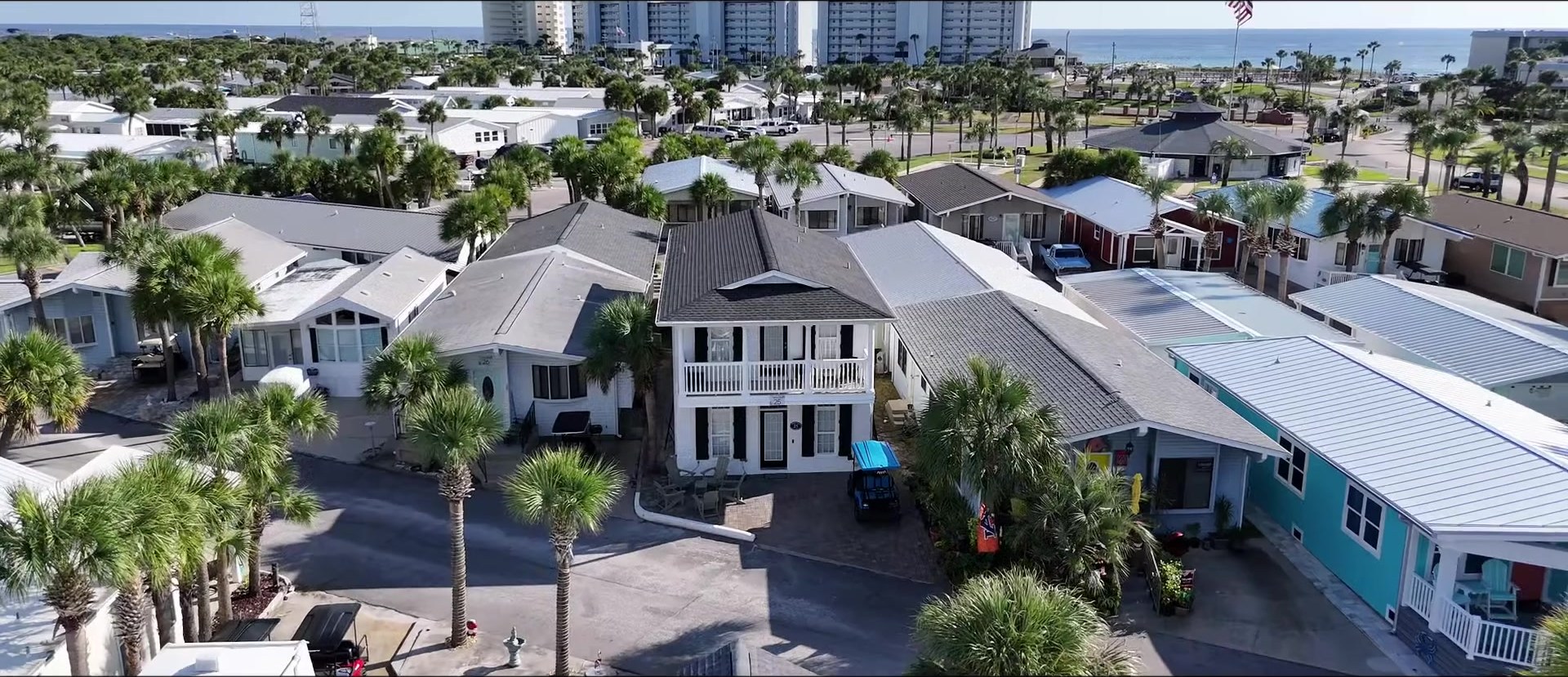 Facebook drone shot of white-painted 25 Gulf Drive with golf cart and the Gulf beyond